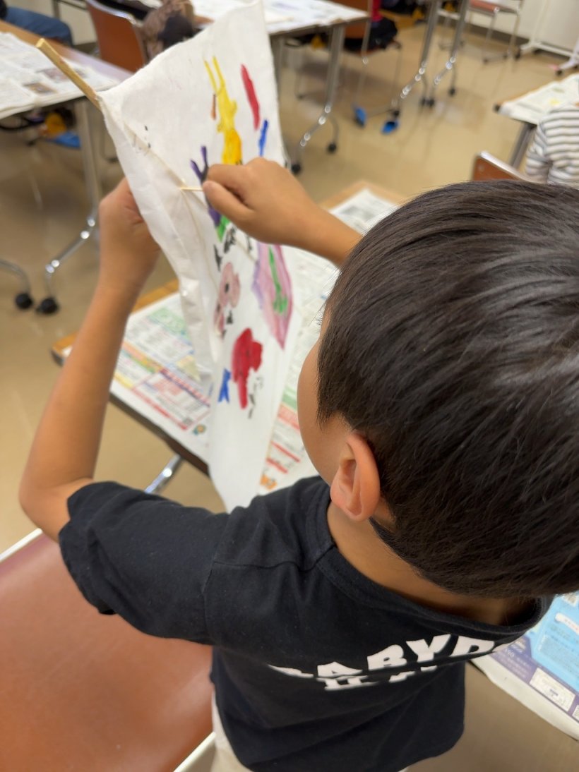 凧の和紙に紐を結んでいる